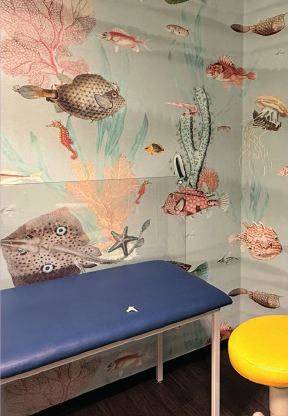 Untersuchungsliege vor einer Unterwasser-Tapete mit Fischen