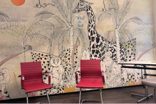 Wartebereich mit roten Stühlen vor einer Dschungel-Wandmalerei mit Giraffe